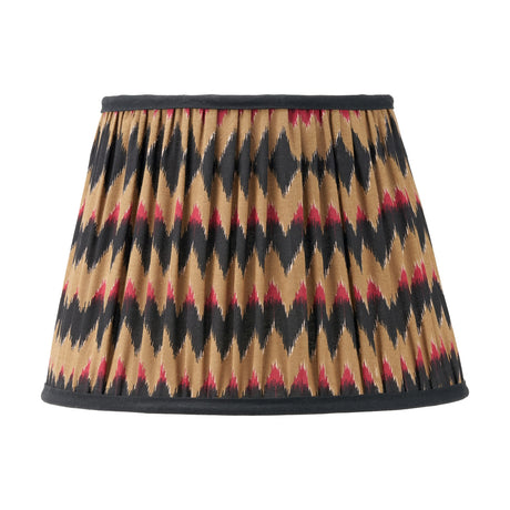 Athira 30cm pleated tapered lamp shade in fabric with multi chevron zigzag pattern in tan, black, and red, finished with black trim, on a plain white background.