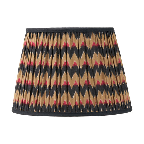 Athira Multi Chevron Design Pleated Tapered Lamp Shade, 35cm, in gathered fabric with a black, gold, and red zig zag pattern and black trim, shown on a plain white background.