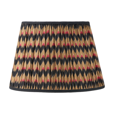 Athira 45cm pleated tapered lamp shade in fabric with a multi chevron pattern in tan, black and red, finished with black trim, shown on a plain white background.