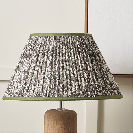 Ornella pleated empire lamp shade, 25cm, in green floral fabric with green trim, shown on a wooden table lamp base against a light background.