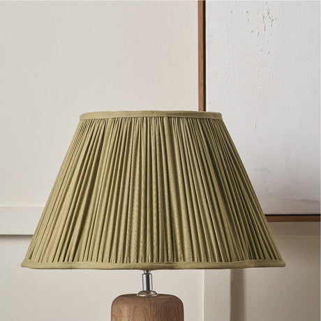 Malia Olive Green Pleated Scalloped Tapered Lamp Shade, 30cm, fabric shade with pleated texture shown fitted on a wooden lamp base against a neutral background.