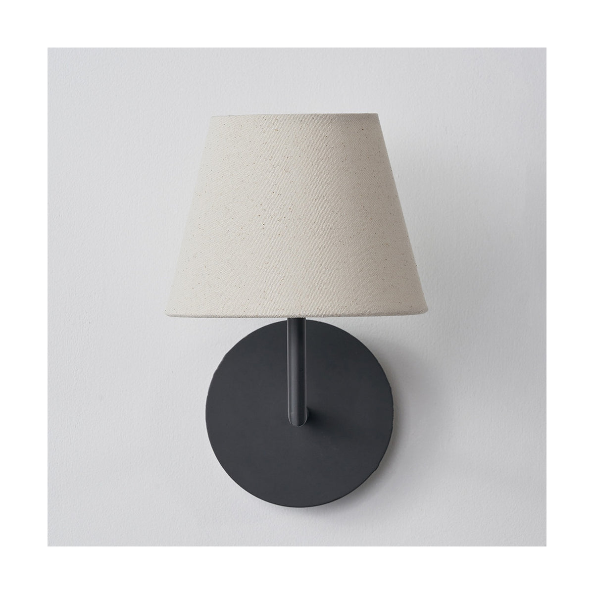 Seychelles Cream Slubby Cotton Empire Lampshade, 16cm, fitted on a wall light with a round matte black backplate, shown against a plain white background.