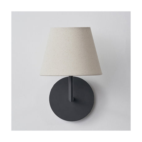 Seychelles Cream Slubby Cotton Empire Lampshade, 16cm, fitted on a wall light with a round matte black backplate, shown against a plain white background.