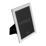 Flat edge silverplated metal photo frame, 8 x 6in rectangular opening, shown at an angle with fold-out stand, on a plain white background.