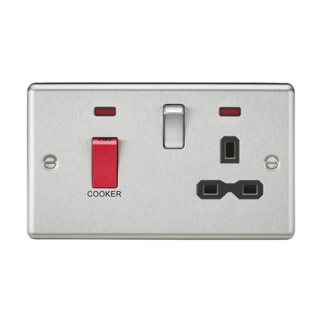 The 45A DP Switch & 13A Socket with Neons, featuring a brushed chrome finish and a black insert with rounded edges, epitomizes the sleek functionality of contemporary cooker control units by combining a dedicated COOKER switch with neon indicators and a standard power outlet.