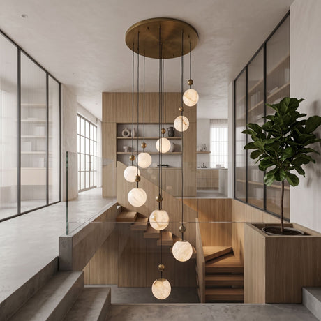 Lorixa 9-light cascading chandelier with staggered alabaster globes in brushed bronze caps, suspended from a round bronze canopy above a wood-panelled staircase.