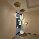 Orlena 3 Light Globe Alabaster Floor Lamp with veined white sphere on copper base, part of a ceiling pendant cluster in a living room setting.