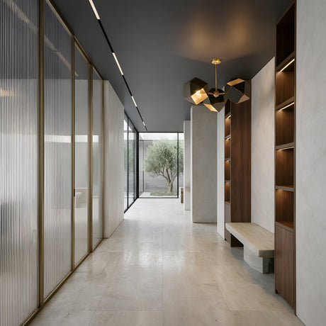 Minimalist modern hallway with marble floors, built-in wooden shelves, a stone bench, glass doors with gold frames, a large window overlooking a courtyard tree, and the Spar 3 Light Pendant in black & gold for a stylish geometric touch.