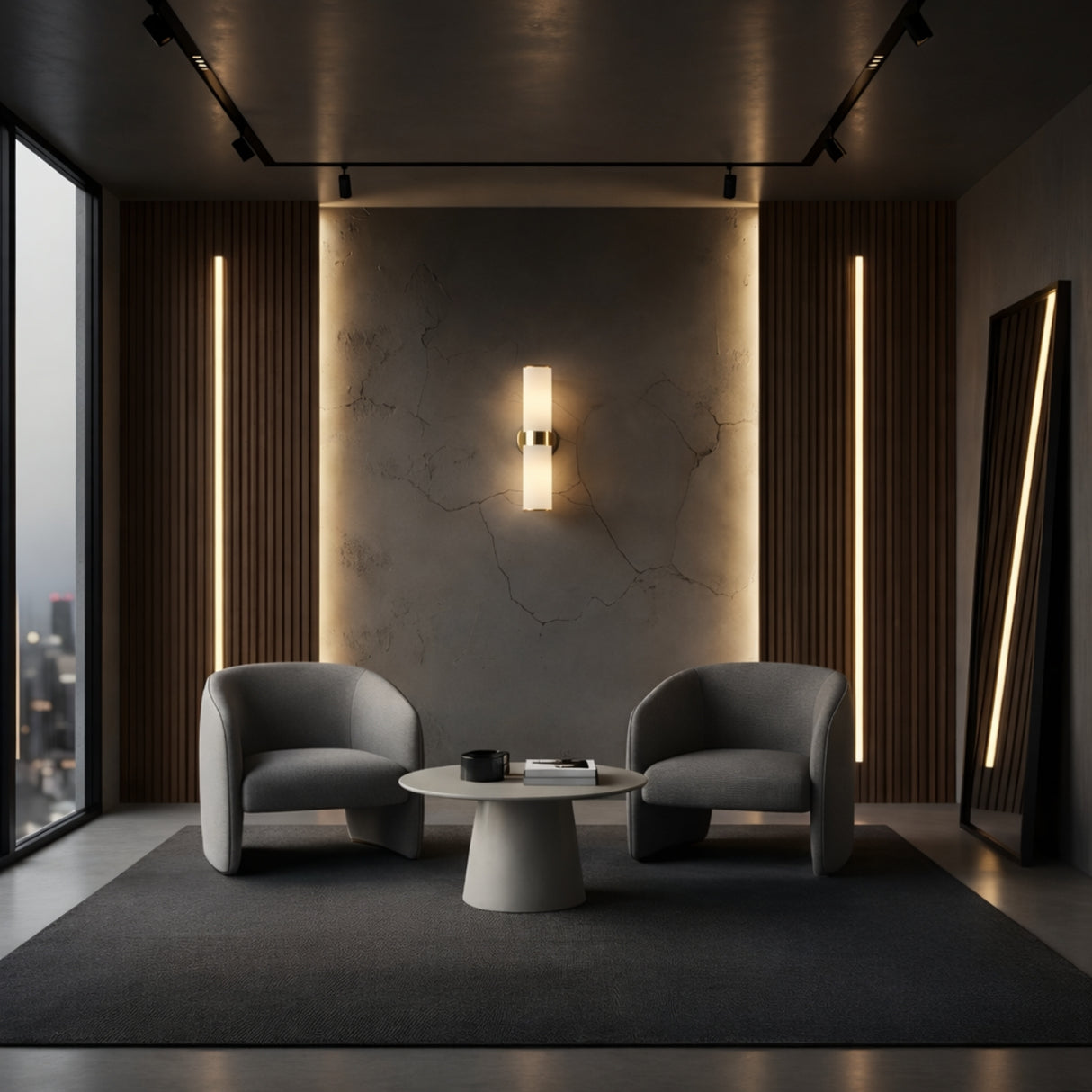 A modern lounge with two gray armchairs, a round white coffee table, and Elaris 2 Light Double Cylinder Alabaster Wall Lights in soft white & brass accenting a textured wall. Large windows reveal a city view; a tall mirror leans against wood paneling.