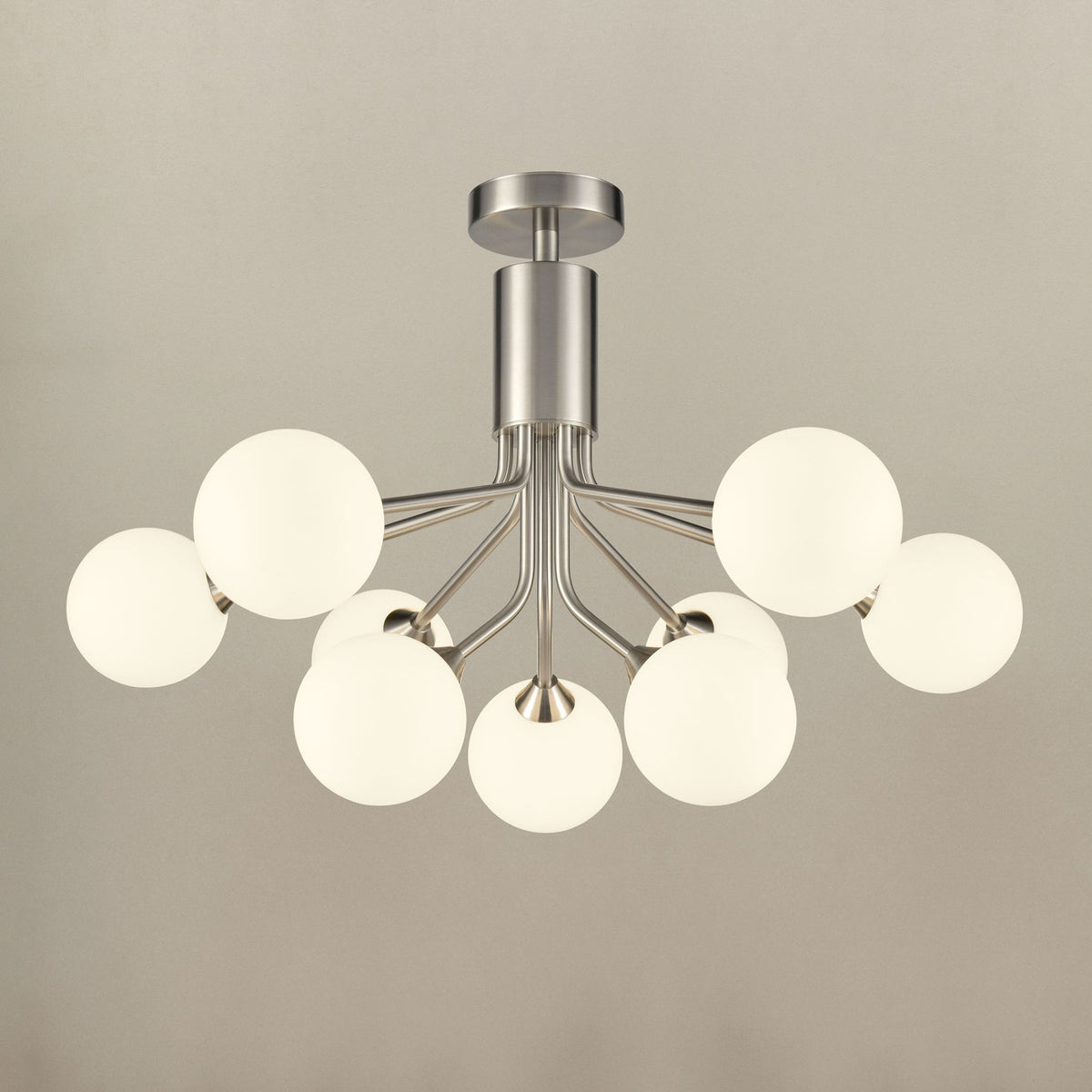 Semi-flush ceiling light with eight brushed nickel arms holding matt opal glass globe shades, shown illuminated against a plain light grey background.