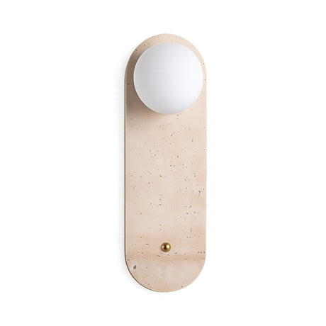The Arvella 1 Light Travertine & Glass Wall Light in light beige features a modern oval travertine backplate, a round white glass globe on top, and a brass accent at the base for a stylish wall sconce design.