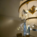 Petraia 2 Tier Floral Alabaster Chandelier in brushed brass, close-up of stone petal tiers and lit bulbs in a room setting.