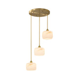 The Vantor 3 Light Alabaster Cluster Pendant Light features three soft white alabaster shades hanging at staggered heights from a round brushed brass mount for a sleek, modern look.