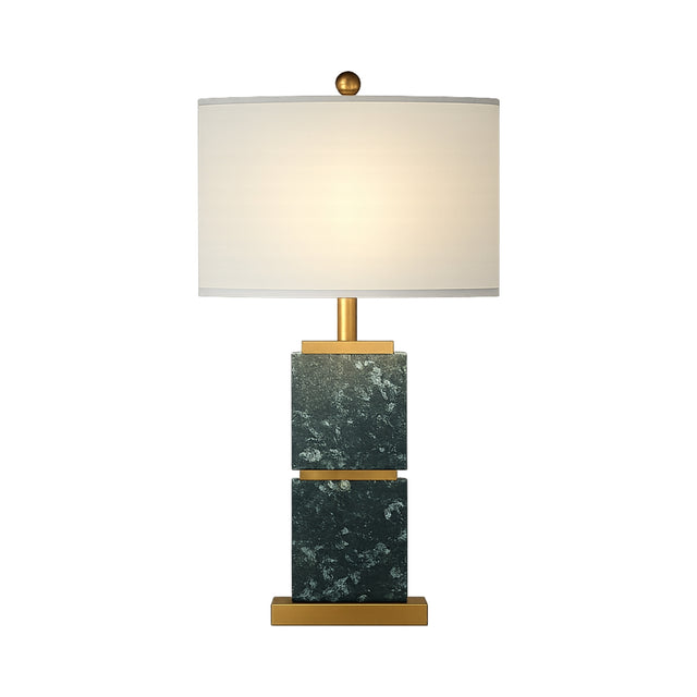 The Veradex 1 Light Marble Block Table Lamp features a green marble rectangular base with brass accents, a gold stem, and a round white lampshade, beautifully illuminated against a white background.