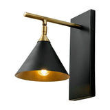 Zeta wall light in matt black and antique brass, with a cone-shaped shade on a horizontal arm and rectangular wall backplate, shown lit against a white background.