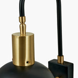Close-up of the Mayfair Matt Black Domed Task Wall Light showing a brushed brass gooseneck arm, cylindrical fitting and domed shade with a black rectangular wall mount.