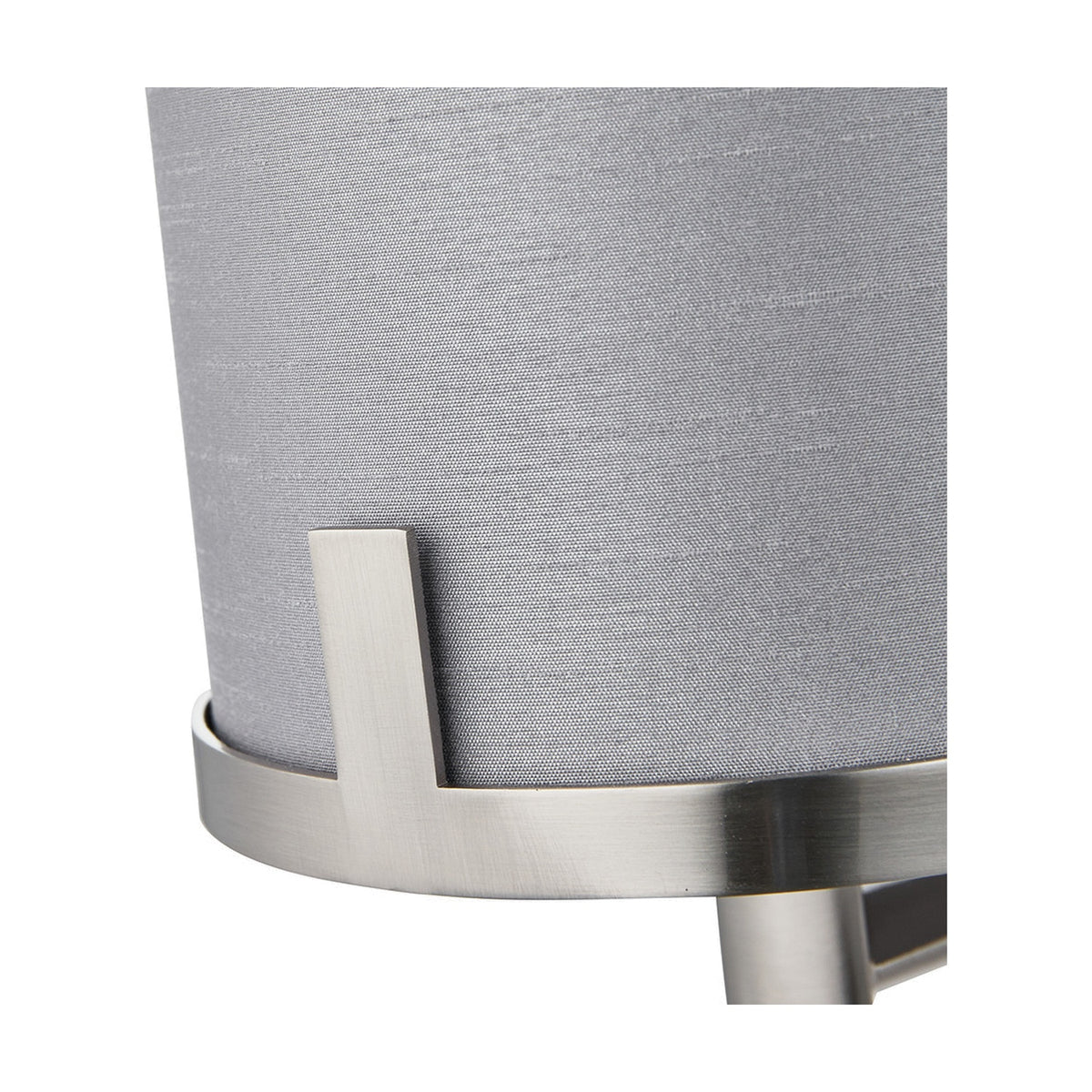 Close-up of the Midland wall light's grey fabric drum shade and brushed nickel bracket detail, showing metal joinery and finish against the shade.
