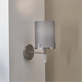 Midland wall light in brushed nickel with a grey cylindrical shade and marble effect base, mounted on a wall corner between light grey and beige walls.