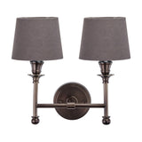 Piero Antique Bronze Double Wall Light with two grey tapered fabric shades on curved arms, joined at a round wall-mounted base, shown on a plain white background.