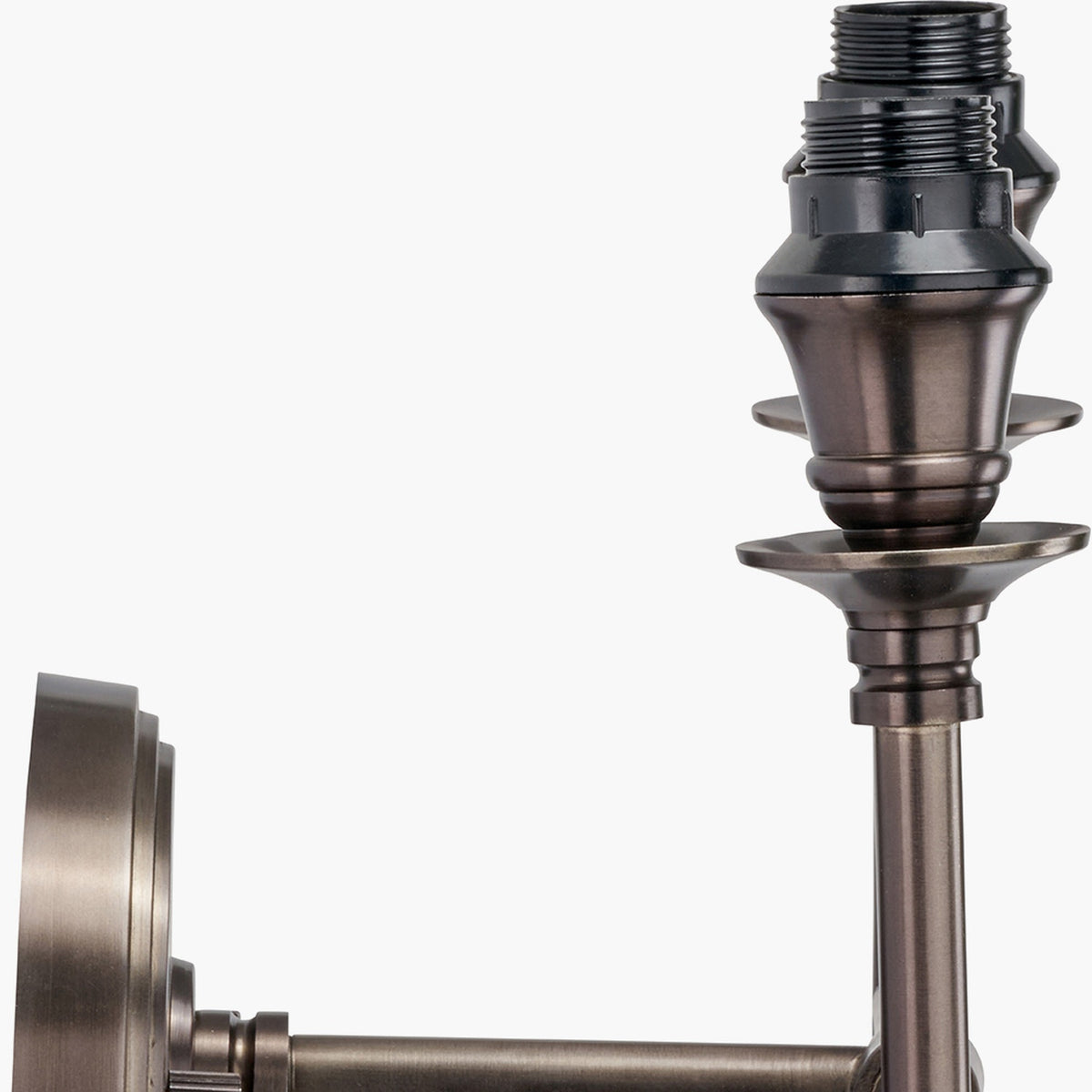 Close-up of the Piero Antique Bronze Double Wall Light, 21cm, showing bronze metal arm with candle-style drip pans and black bulb sockets against a white background.