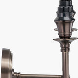 Close-up of the Piero Antique Bronze Double Wall Light, 21cm, showing bronze metal arm with candle-style drip pans and black bulb sockets against a white background.