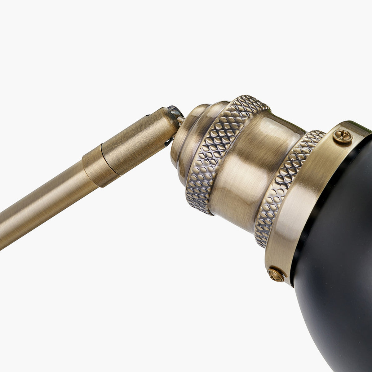 Close-up of the Augusto Black & Gold Task Wall Light, showing a knurled brass joint and adjustable rod connecting to a matte black shade, on a plain white background.