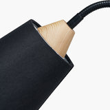 Close-up of the Juna Black Metal & Wood Wall Light showing a black linen-covered shade with a natural wood cone fitting and black flexible gooseneck arm, on a plain white background.