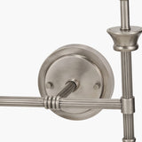 Close-up of the Salvatore wall light's round wall mounting plate in antique silver metal, showing reeded arms and knurled screw detailing against a white background.