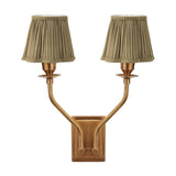 Tatiana antique brass double wall light with two upward-curving arms and pleated olive green fabric shades, shown against a plain white background.