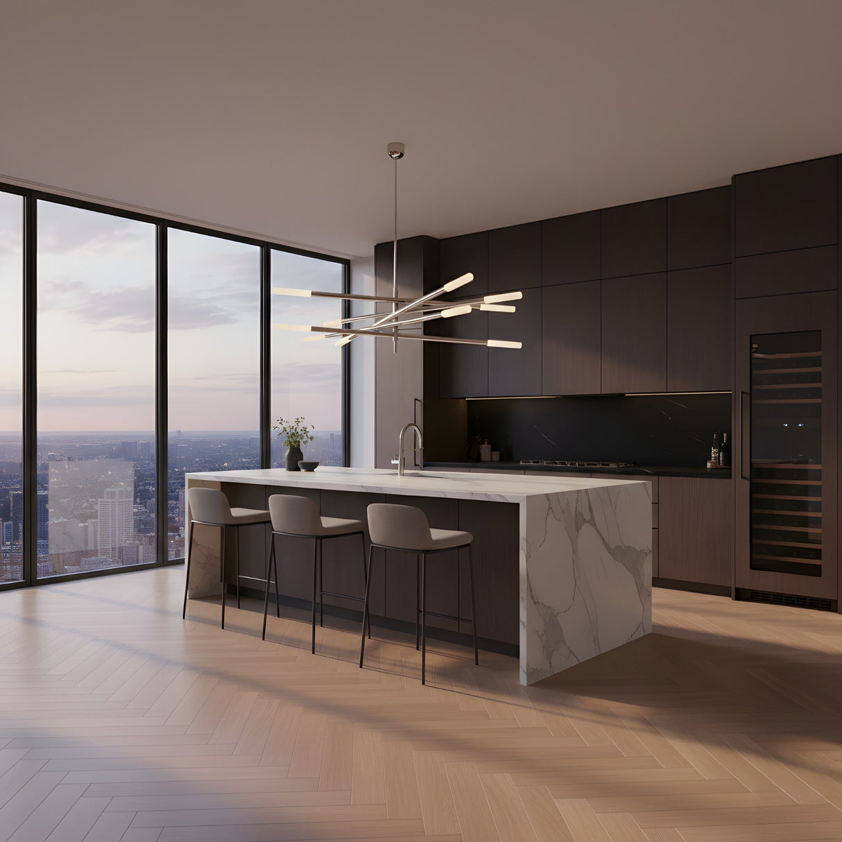 A modern kitchen with dark cabinets, a marble island and city-view windows at sunset is elegantly lit by the Aurelian LED Layered Arms Alabaster Chandelier in Satin Nickel & Soft White as the standout contemporary light fixture.