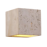 The Cavaro LED Cube Travertine Wall Light in light beige features a cube-shaped travertine exterior and warm LED glow from the open bottom, offering modern elegance to any space.