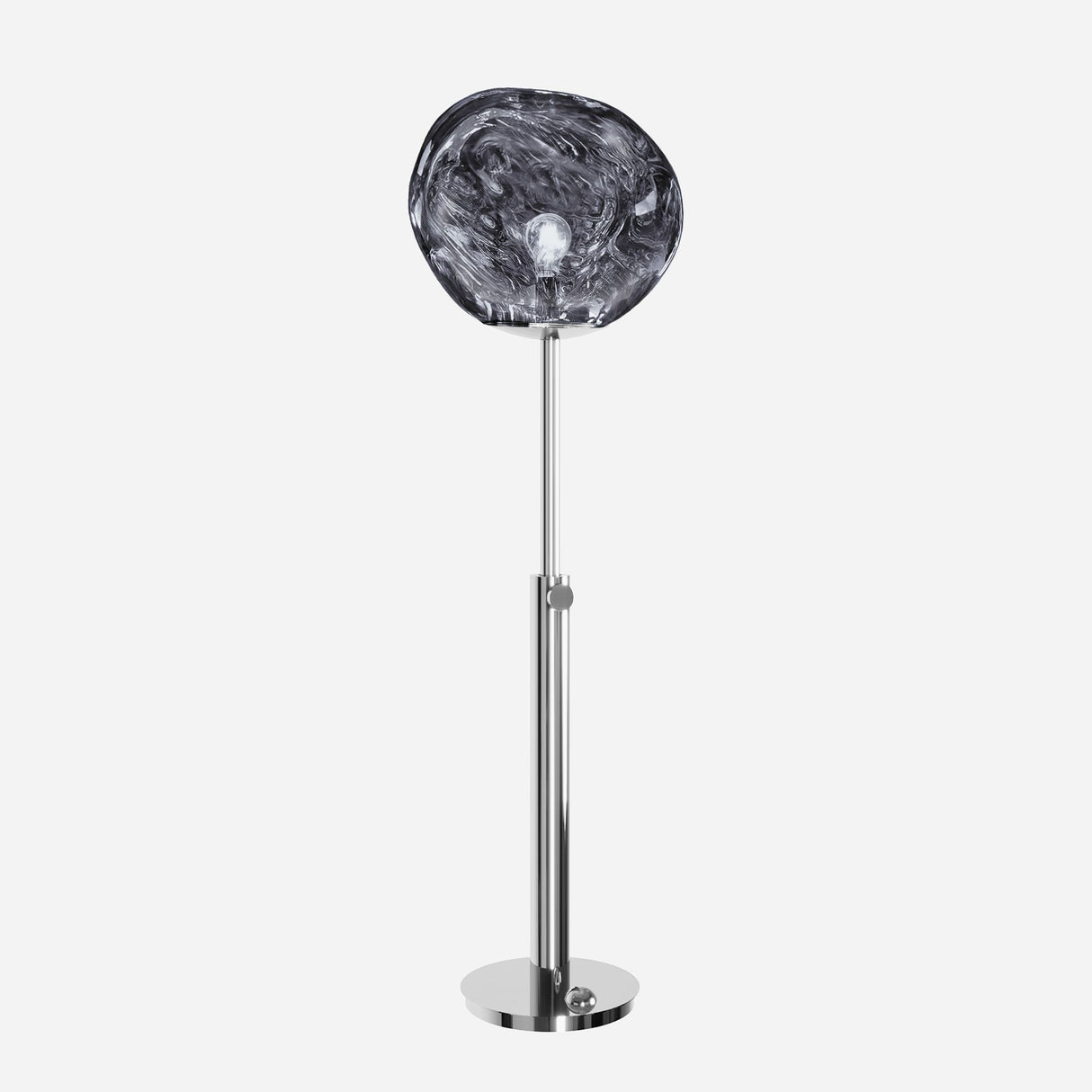 Introducing the Lava Floor Lamp in Silver: This contemporary lamp features a sleek metal stand paired with a distinctive, transparent swirling glass shade that mimics organic forms. Its artistic design subtly hints at molten effects, all set against a simple white backdrop.