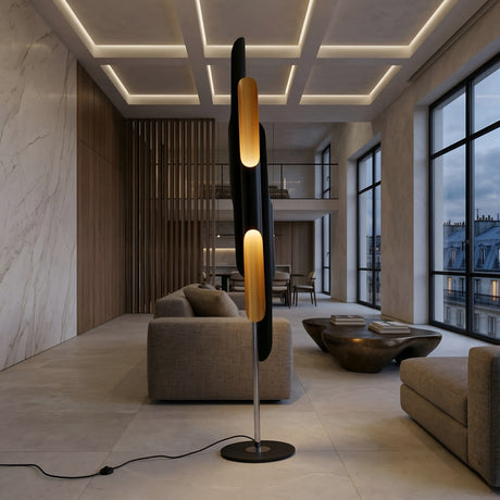 A modern living room with marble walls, large windows, neutral-toned sofas, and the Stealth 6 Light Floor Lamp in brass and black. A contemporary coffee table sits at the center of the space.