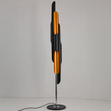 Niori Stealth 6 Light Floor Lamp with staggered matt black tubular shades and brushed brass interiors on a polished chrome stem and round black base.