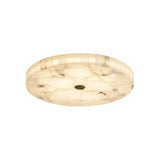 The Veltrix LED Small Round Alabaster Flush Ceiling Light in soft white and brushed brass features marble-like patterns and a central accent, providing a warm, diffused glow for any space.