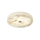 The Veltrix LED Small Round Alabaster Flush Ceiling Light features soft white illumination, a marble-like alabaster shade with beige veining, a polished finish, a modern minimalist design, and brushed brass accents with a small central hole.