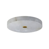 The Aleron LED Small Round Alabaster Flush Ceiling Light in soft white with a brushed brass accent features a marble-like pattern, making it perfect for mounting flush on a plain ceiling.