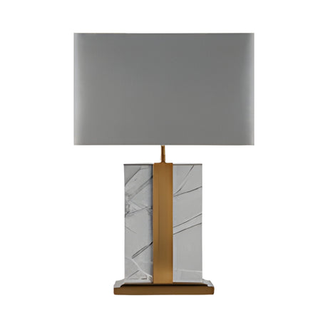 The Elvaris 1 Light Framed Marble Table Lamp features a brass accent, rectangular grey shade, and a base of white marble with gray veins atop a brass and marble platform.