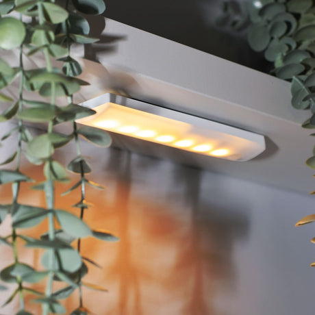 LYYT motion sensing LED light with 21 LEDs behind a frosted diffuser in a white housing, mounted under a shelf beside trailing eucalyptus foliage.