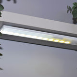 LYYT 36 LED motion sensing light bar by AVSL, illuminated in white mode on a magnetic adhesive strip mounted beneath a white shelf.
