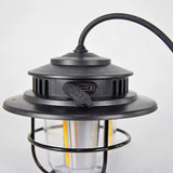 Close-up of the LYYT Rechargeable LED Outdoor Lantern by AVSL in matt black, showing the USB-C charging port, textured housing, wire cage, and hanging cord.