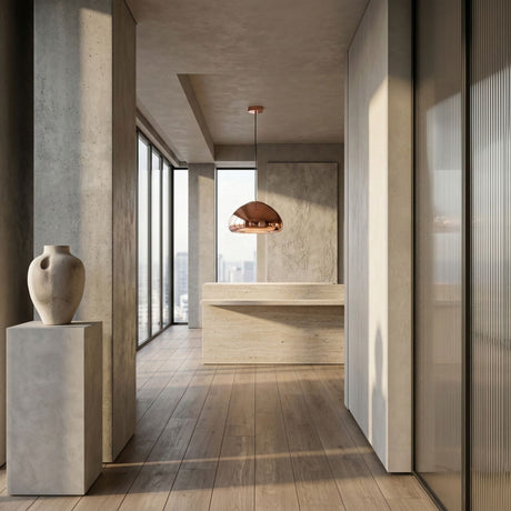 Minimalist modern interior with large windows, light wood floors, a beige stone pedestal holding a ceramic vase, a rectangular stone table, and the Gulf Glass Pendant Light - Copper adding modern flair, with a cityscape visible outside.