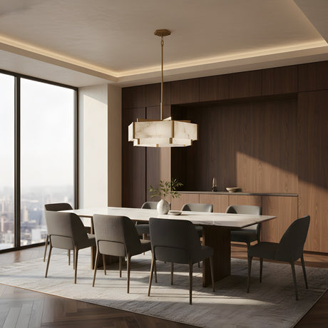 A modern dining room features a large white table, eight gray chairs, a white vase with greenery, wooden walls, a sideboard, a city-view window, and the Albyso LED Twin Drop Alabaster Chandelier in brushed brass & soft white above the table.