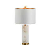 The Calix 1 Light Faceted Pillar Alabaster Table Lamp features a brushed brass base and soft white shade, offering elegant ambient lighting with its modern design against a white background.
