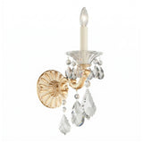The Vienna 1 Light K9 Crystal Wall Light features an heirloom gold finish, candle-style bulb, clear glass plate, hanging crystal pendants, and an ornate Rococo-inspired round wall mount.