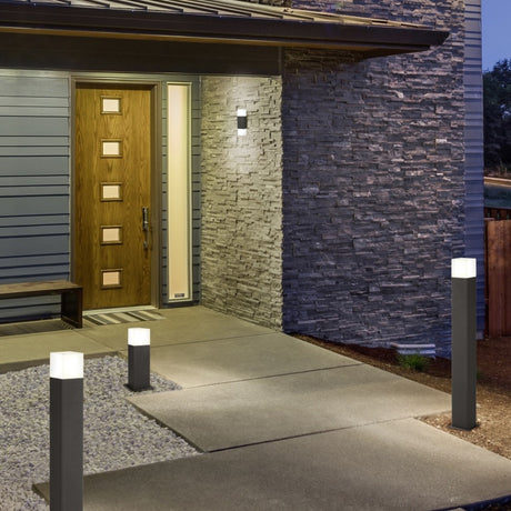 Hudson 80cm LED outdoor lamp posts in anthracite with white acrylic shades, illuminating a stone garden path beside a modern house entrance at dusk.