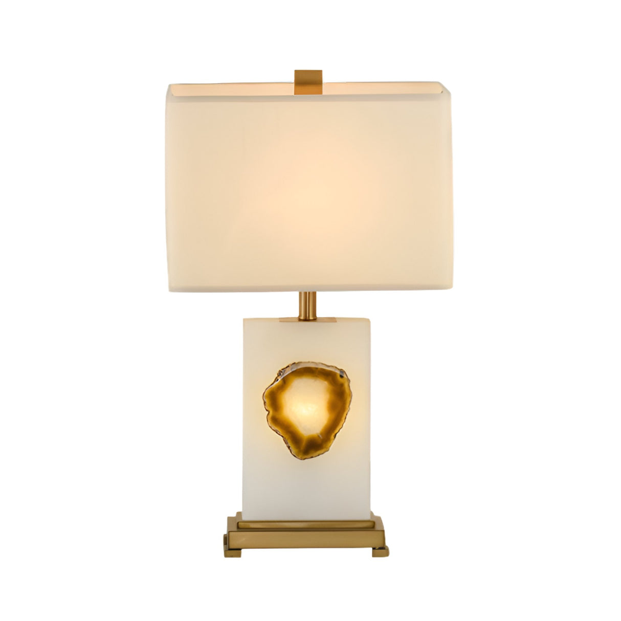 The Selune 1 Light Sculpted Core Alabaster Table Lamp features a modern alabaster base with a brushed brass geode-like accent, gold detailing, and a soft white rectangular shade.