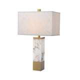 The Ravelle 1 Light Linear Column Alabaster Table Lamp features a sculptural alabaster base with natural veining, brushed brass accents, and a rectangular soft white fabric shade for a modern look.