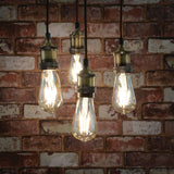 LYYT ES Quad Pendant Set in antique brass by AVSL, four E27 lamp holders on braided cables with Edison filament bulbs, shown against a red brick wall.