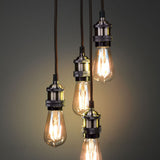LYYT ES Quad Pendant Set in antique brass by AVSL, four E27 lamp holders on braided cables at staggered drops with lit Edison filament bulbs.